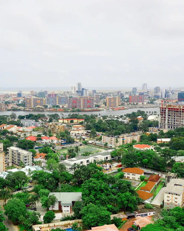 Aerial view over Ikoyi, Lagos, with the lagoon and the city skyline beyond.